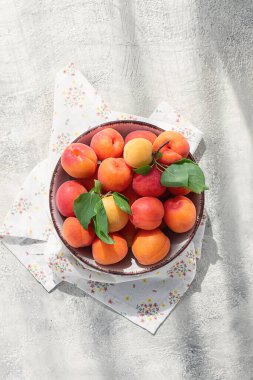 Kasede taze kayısılar, parlak bir masada, doğal ışık, üst manzara, insan yok.,