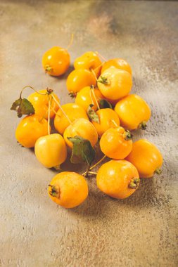 Sarı küçük elmalar, Çin çeşitleri, masaya saçılmış, üst manzara, insan yok.,