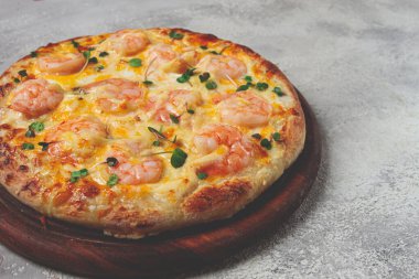 Dört peynirli karides ve taze mikro yeşil pizza, ahşap bir tahtanın üzerinde servis ediliyor, ev yapımı, insan yok.,
