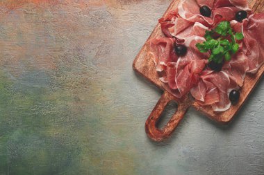 Kesme tahtasında dilimlenmiş jambon, zeytin ve otlarla, atıştırmalık, kahvaltı, insan yok.,