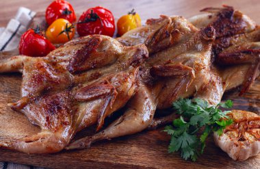 Izgara bıldırcın eti, ahşap kesim tahtasında, tütünde, fırında, baharatlarla, ev yapımı, insansız.,