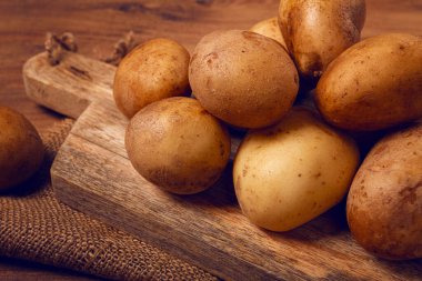 Çiğ patates, doğrama tahtasına saçılmış, yakın plan, insan yok.,