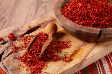 Baharat safranı iplikleri, ahşap bir kasede, ahşap bir masanın üstünde, üst manzara, yakın çekim.,