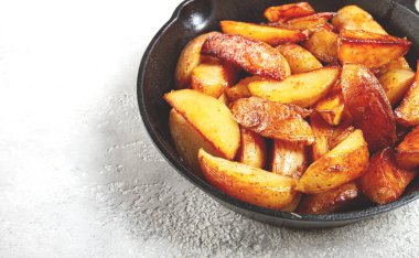 Kızarmış patates dilimleri, dökme demir bir tavada, ev yapımı, insan yok.,