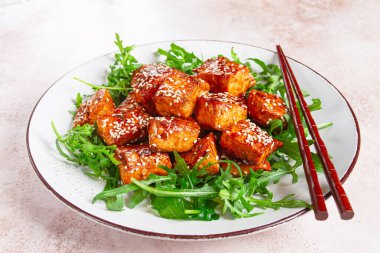 Kızarmış somon dilimleri, susamlı teriyaki roka salatası, en iyi manzara.,