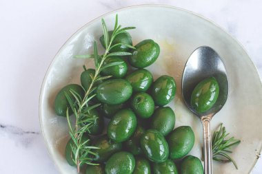 Chalkidiki zeytinleri, klasik Yunan yeşil zeytinleri, bir tabakta, kaşık, üst manzara, insan yok.,