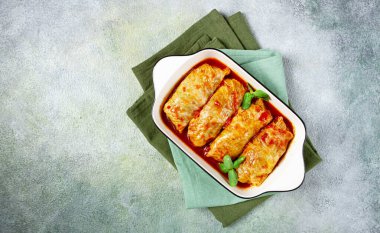 Doldurulmuş lahana ruloları, kıymalı et, domates sosu, üst manzara, insanlar olmadan, spot ışıkları altında..