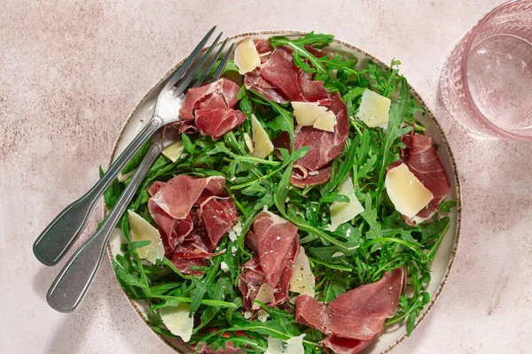 Prosciutto ve rendelenmiş parmesan peynirli taze roka salatası, tabakta, ev yapımı, insan yok.,