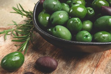 Chalkidiki zeytinleri, klasik Yunan yeşil zeytinleri, kesme tahtasındaki bir kasede, üst manzara, insanlar olmadan.,