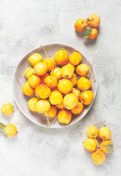 Sarı küçük elmalar, Çin çeşitleri, gri bir tabakta, üst manzara, insan yok.,