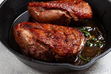 Kızarmış ördek göğsü, kızartma tavasında, baharat ve otlarla, yakın plan, insan yok.,