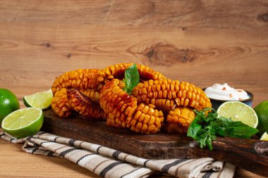 Mısır pirzolası, krema soslu, baharatlı ve limonlu, aperatif, ahşap kesim tahtasında, ev yapımı, insan yok.,