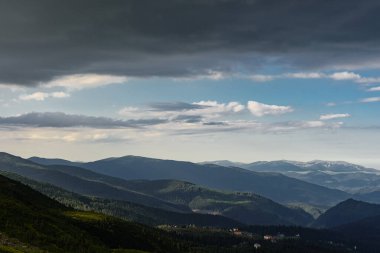 Dağdaki büyük gri bulutların altında kırsal bölgede. Kayanın en üst manzarası. Alplerin en yüksek noktalarından biri.