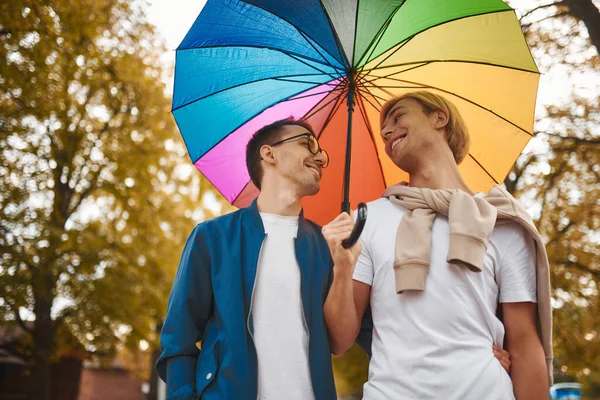 可爱的同性恋夫妇带着彩虹伞在户外散步 两个帅哥在公园里谈恋爱Lgbt概念 — 图库照片
