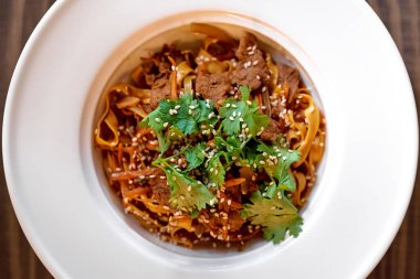 Sığır eti, kinoa tohumu ve ahşap tahtada yeşillik ile nefis bir makarna manzarası. Kafeler ve restoranlar için konsept. Yemek fotoğrafı. Sağlıklı yiyecekler. Diyet yapıyorum. Bahar menüsü. Vejetaryen yemeği.