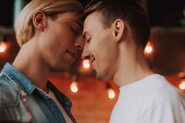 Evdeki sevecen eşcinsel çift. Mutfakta sarılıp öpüşen iki yakışıklı adam. LGBT kavramı.