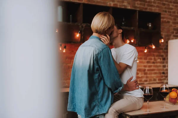 Evdeki sevecen eşcinsel çift. Mutfakta sarılıp öpüşen iki yakışıklı adam. LGBT kavramı.