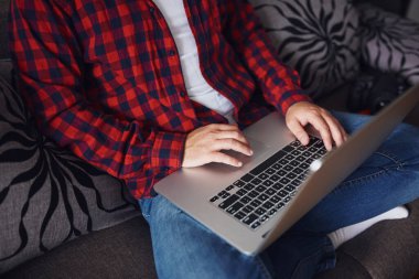 Evde tele-çalışma kavramı. Coronavirus salgınından sonra evde çalışan şık bir erkek. Karantina sırasında evde kalıp çalışın. Merkez Ofis