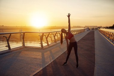 Karantina koşullarında sabah egzersizleri. Dikkatli kız koşuya hazırlanıyor. Sabah egzersizleri gün doğumunda.