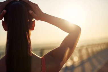 Güzel kız gün doğumunda spor yapıyor ve poz veriyor. Genç bir kadının bakış açısı. Şehirde spor haberleri. Şehir konseptinde sağlıklı yaşam tarzı. Sabahları koşuyorum.