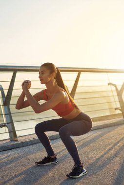 Çekici kız güneş doğarken spor yapıyor ve poz veriyor. Şehirde spor haberleri. Şehir konseptinde sağlıklı yaşam tarzı. Sabahları koşuyorum. Koşmaya hazırlanılıyor.