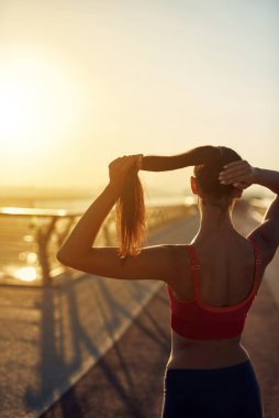 Güzel kız gün doğumunda spor yapıyor ve poz veriyor. Genç bir kadının bakış açısı. Şehirde spor haberleri. Şehir konseptinde sağlıklı yaşam tarzı. Sabahları koşuyorum.