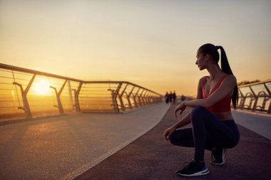 Karantina koşullarında sabah egzersizleri. Dikkatli kız koşuya hazırlanıyor. Sabah egzersizleri gün doğumunda.