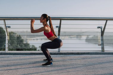 Çekici kız güneş doğarken spor yapıyor ve poz veriyor. Şehirde spor haberleri. Şehir konseptinde sağlıklı yaşam tarzı. Sabahları koşuyorum. Koşmaya hazırlanılıyor.