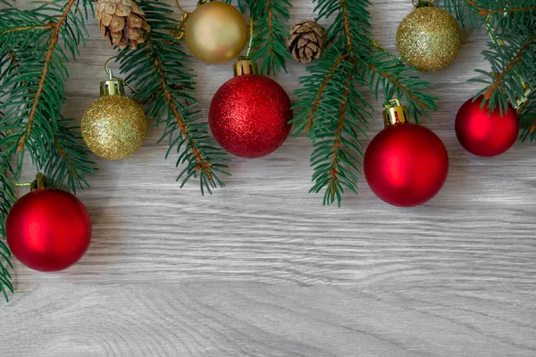Composición navideña de ramas de abeto, conos de abeto y rojo, bolas de oro en tablas de madera — Foto de Stock