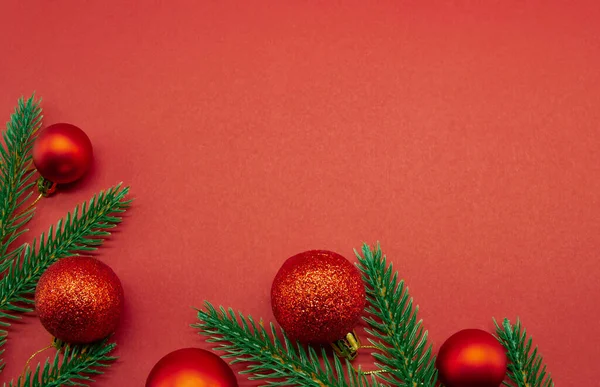 Bolas rojas de Navidad con ramas de abeto sobre fondo rojo — Foto de Stock