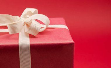 Parlak arkaplanda kurdeleli kırmızı hediye kutusu