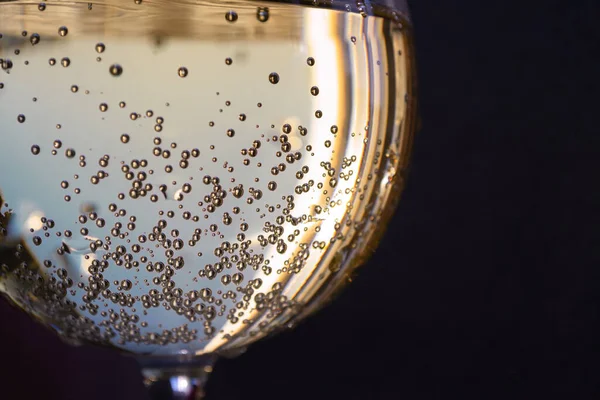 Massor av luftbubblor i ett närglas champagne. Stockbild