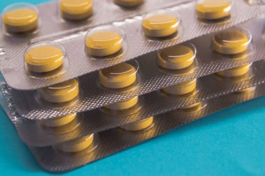 Mavi arka planda su toplamış sarı haplar.