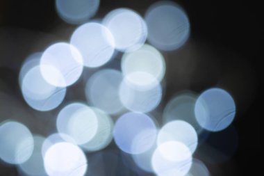 Koyu arkaplanda yuvarlak mavi bir bokeh. Bulanık arkaplan