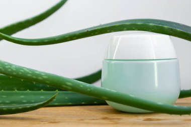 Aloe Vera yaprakları ve ahşap bir arka planda kozmetik için bir kavanoz. Aloe vera ile doğal kozmetik ürünleri.