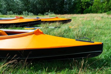 Bir grup turuncu kano güneşli bir günde çimlerin üzerinde