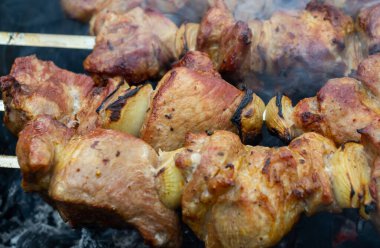 Metal bir şişe bağlanmış domuz şişleri ve ızgarada kızartma.