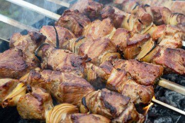 Metal bir şişe bağlanmış domuz şişleri ve ızgarada kızartma.