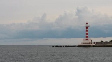 Deniz feneri. Deniz Burnu. Suyun üstündeki kuşlar, sudan çıkan kayalar. Zaman Hızı görüntüsü.