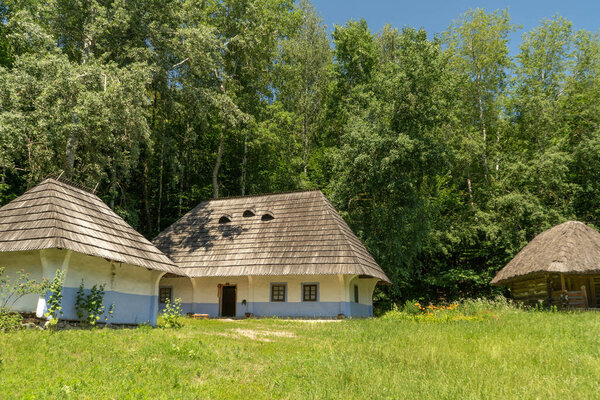 Old, medieval, traditional Ukrainian rural houses on a hill in the forest.