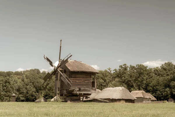 古老的风车和中世纪的 传统的乌克兰乡村房屋在绿色的草地上 蓝天白云 旧照片 — 图库照片