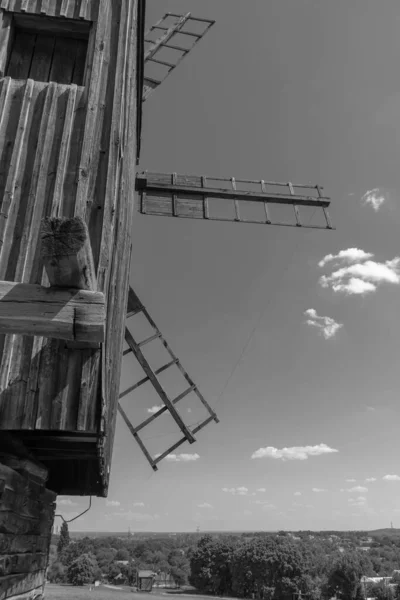 Antiguo molino de viento en un prado verde, campo. Cielo azul con nubes blancas. Foto vieja. Foto en blanco y negro. — Foto de Stock