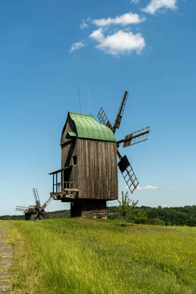 Antiguo molino de viento en un prado verde, campo. Cielo azul con nubes blancas. —  Fotos de Stock