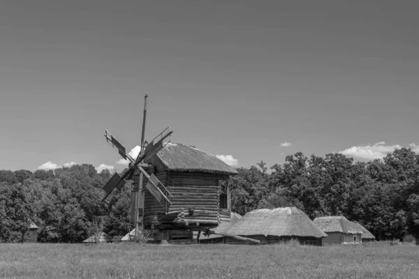 古老的风车和中世纪的 传统的乌克兰乡村房屋在绿色的草地上 蓝天白云 旧照片 黑白照片 — 图库照片