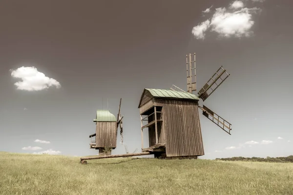 Antiguo molino de viento en un prado verde, campo. Cielo azul con nubes blancas. Foto vieja. —  Fotos de Stock