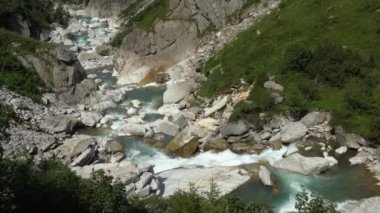 İsviçre Alplerinde kristal berrak suyu olan fırtınalı bir dağ nehrinin görüntüleri.