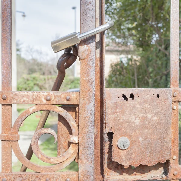 Roestige metalen poort gesloten met hangslot — Stockfoto