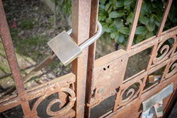 Roestige metalen poort gesloten met hangslot — Stockfoto