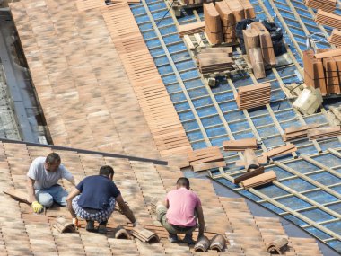 Fayans döşeme için çatı üzerinde çalışmak için masonlar