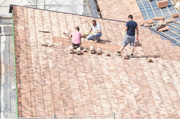 タイルを置くための屋根上で動作する石工 — ストック写真